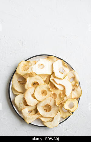 Apple dehydrated fruit chips on white background, copy space, healthy vegan snack. Stock Photo