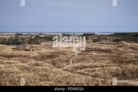 Holiday homes nestled within the grassy sand dune landscape near Hvide Sande in Denmark Stock Photo