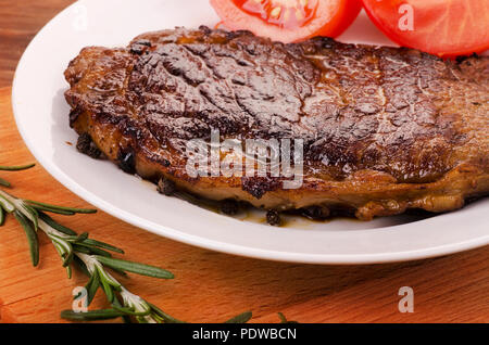 Grilled sliced barbecue beef  on a white plate with rosemary Stock Photo