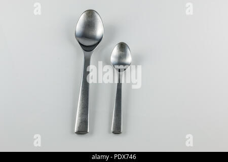 Steel cutlery with table spoon and little spoon Stock Photo