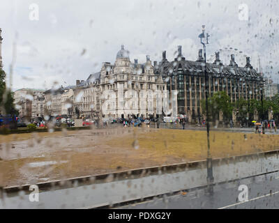 Westminster. London. UK 10 Aug 2018 - View of Portcullis House and London Eye through a double decker bus window covered with raindrops.  Credit Roamwithrakhee /17�Թ����� Live News Stock Photo