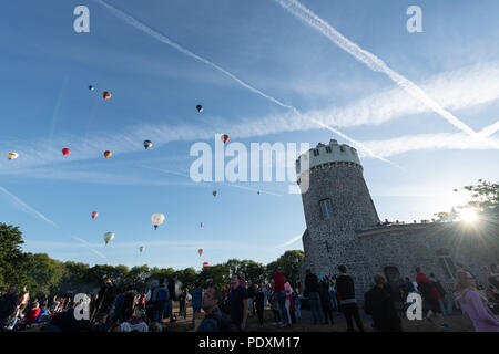 Bristol, UK, 11th August, 2018. Crowds photographing Hot Air Balloons flying over the Clifton Observatory, after the first Mass Ascent from the Bristol Balloon Fiesta 2018. Credit: Steve Davey/Alamy Live News. Stock Photo