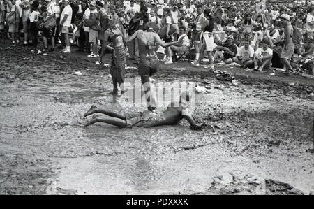 Three People in Mud during Woodstock Music Festival, Saugerties, New York, USA, July 13, 1994 Stock Photo
