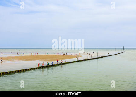 Barrier at the mouth of the River Arun estuary entering the sea at East Beach, seen from West Beach, Littlehampton, a resort in West Sussex  in summer Stock Photo