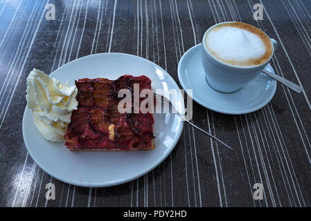 Plum cake, plum chutney with cream and cappuccino, Germany Stock Photo