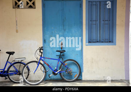 Bicycle leaning against a white painted brick wall Stock Photo