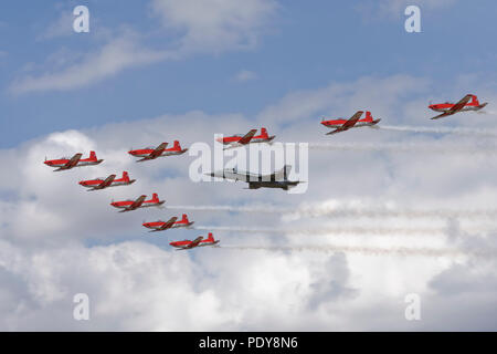 The Swiss Air Force Aerobatic Display Team in their PC-7 Turbotrainers fly in formation with a Swiss F/A-18C Hornet at the RIAT Stock Photo