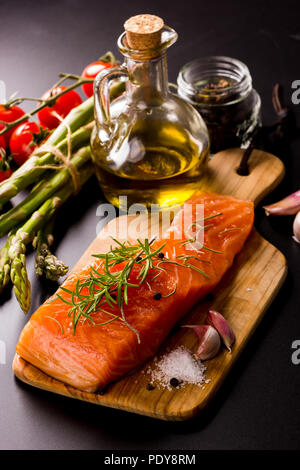 Salmon fillet seasoned with various spices on black background Stock ...