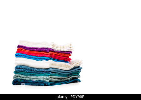 Photo of stacks multi-colored towels on empty white background. Blank space for text Stock Photo