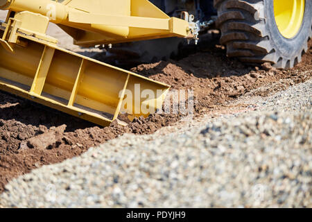 Grader digging a ditch for draining on a gravel driveway Stock Photo ...