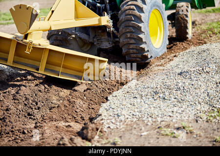 Grader digging a ditch for draining on a gravel driveway Stock Photo ...