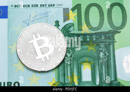 Silver bitcoin on 100 euro banknote on macro. Stock Photo