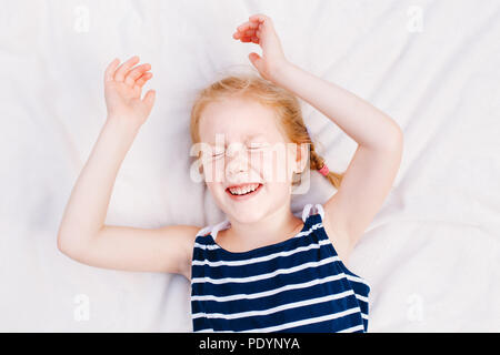 9 Year Old Laughing Little girl with freckles smiling and laughing at the 