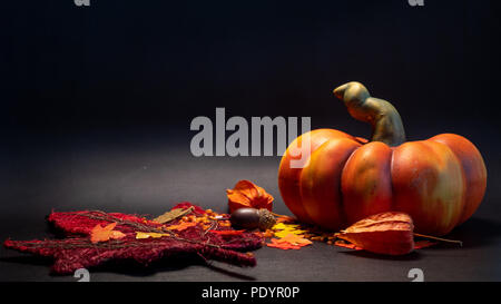 autumn fall decoration scene with artificial pumpkin leaves in orange color on black background studio Stock Photo