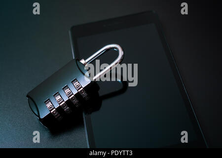 Combination Lock Leaning On A Smartphone - Mobile Phone Security Concept Stock Photo