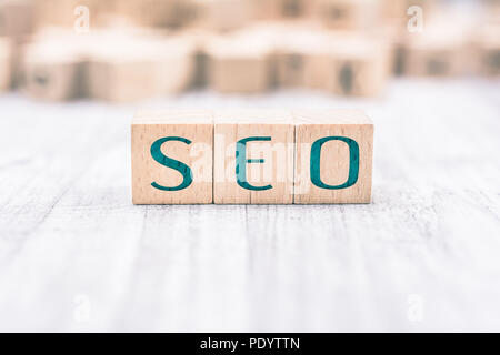 The Word SEO Formed By Wooden Blocks On A White Table Stock Photo