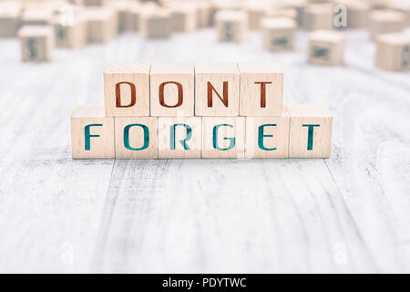 The Words Don't Forget Formed By Wooden Blocks On A White Table, Reminder Concept Stock Photo