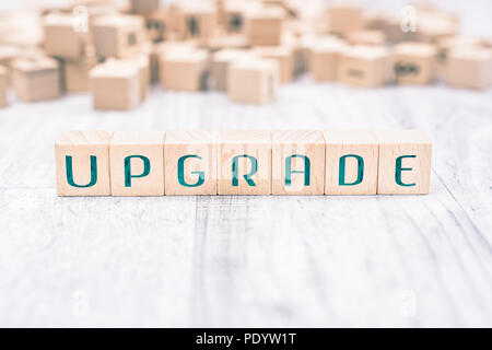The Word Upgrade Formed By Wooden Blocks On A White Table, Reminder Concept Stock Photo