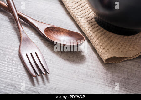 Wooden Set Of Fork And Knife Next To A Bowl With Napkin On A Table, High Angle View Stock Photo