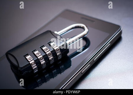 Combination Lock Lying On A Mobile Phone - App Security Concept Stock Photo