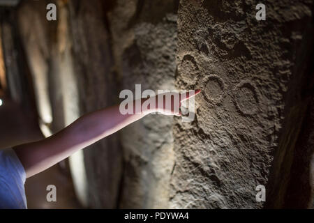 Trigueros, Spain - July 2nd, 2018: Child pointing to Dolmen de Soto engravings, circles. The biggest one megalithic monument in the province of Huelva Stock Photo