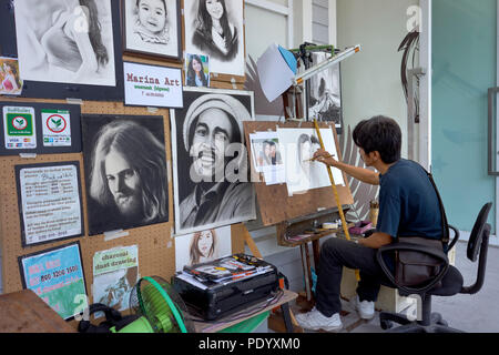Artist studio. Artist at work in a studio with a vast array of his work on display. Thailand art studio. Southeast Asia Stock Photo
