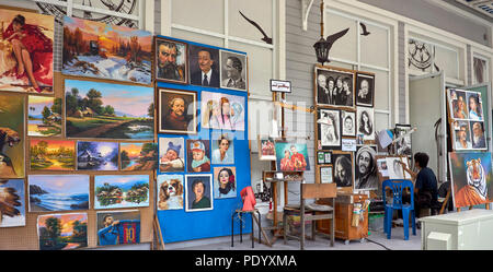 Artist studio. Artist at work in a studio with a vast array of his work on display. Thailand art studio. Southeast Asia Stock Photo
