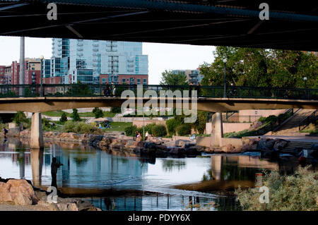 Shadows of the city ripple across the river as Denver residents enjoy Confluence Park at sundown.  Exclusive rights managed stock photo and Denver cor Stock Photo