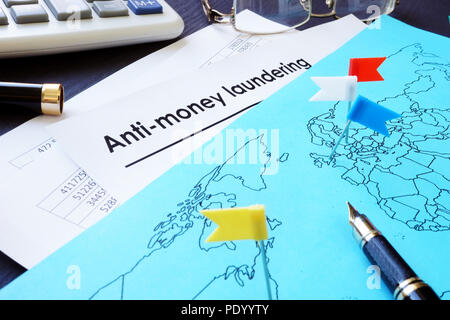 Anti-Money Laundering (AML) documents and world map. Stock Photo