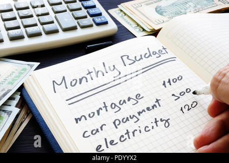 Man is writing Monthly Budget Plan. Home finances. Stock Photo