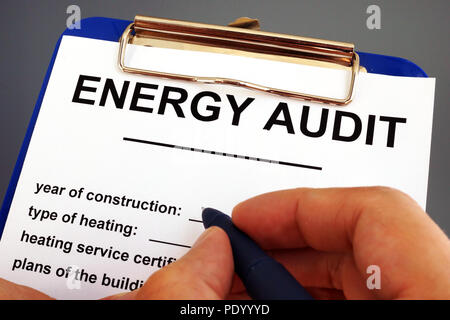 Man filling in energy audit form in a clipboard. Stock Photo