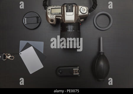 top view of work space photographer with dslr camera system, camera cleaning kit and camera accessory on black table background Stock Photo