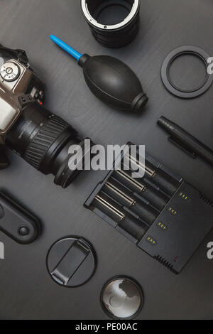 top view of work space photographer with dslr camera system, camera cleaning kit and camera accessory on black table background Stock Photo