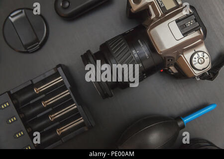 top view of work space photographer with dslr camera system, camera cleaning kit and camera accessory on black table background Stock Photo