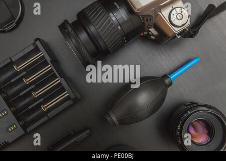 top view of work space photographer with dslr camera system, camera cleaning kit and camera accessory on black table background Stock Photo