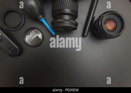 top view of work space photographer with dslr camera system, camera cleaning kit and camera accessory on black table background with copy space Stock Photo