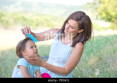 Young mother arranging her daughter's hair Stock Photo