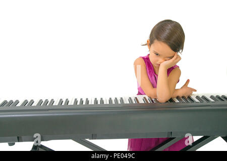 little girl being tired while practising the piano Stock Photo