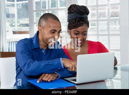 African american couple at computer at desk at home Stock Photo