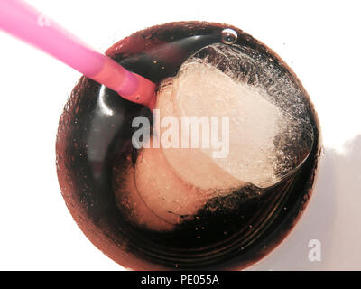 Close up of ice cubes and plastic straw in glass of coke Stock Photo