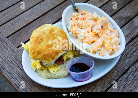 Local sausage, egg and cheese biscuit sandwich with cheese grits, Cahawba House Restaurant, Montgomery, Alabama, USA Stock Photo