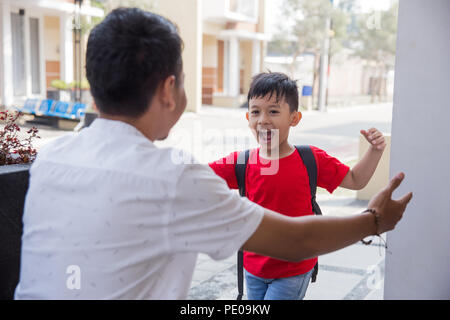 Happy family son running and hugging dad after going back from school Stock Photo