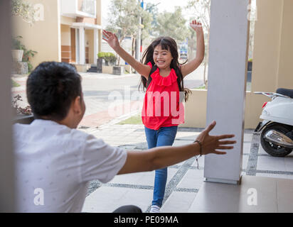 Happy family daughter running and hugging dad after going back from school Stock Photo