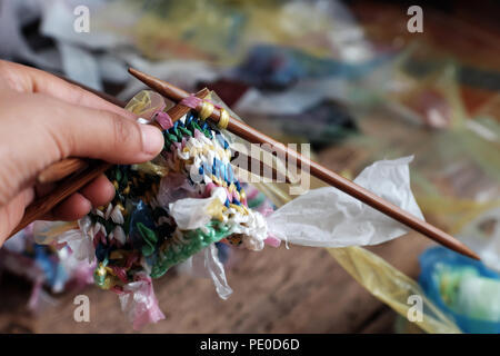 Cut nylon bag into yarn and woman hand knit to basket, good idea to recycle nylon bag to reduce environmental pollution Stock Photo