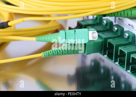 Fiber optical network cables connected to equipment in data center Stock Photo