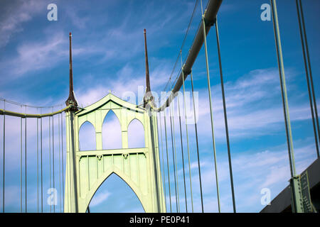 The large famous gothic arched transportation St Johns bridge across the Willamette River in Portland Oregon Down Town in sunny weather with clouds bl Stock Photo