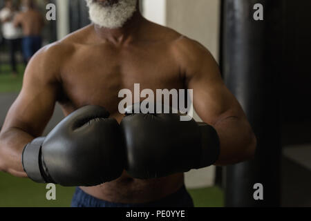 Senior man in black boxing gloves Stock Photo