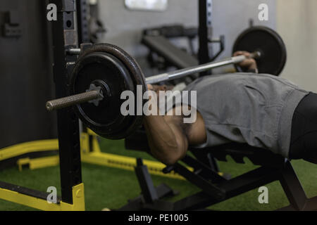 Senior man exercising with barbell in the fitness studio Stock Photo