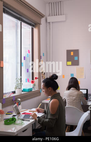 Fashion designers working on laptop in design studio Stock Photo