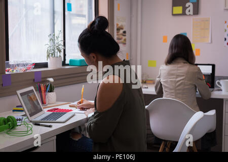 Fashion designers working on laptop in design studio Stock Photo